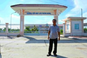 Anh Trương Dũng đứng trên phần đất của mình đã hiến xây trường.